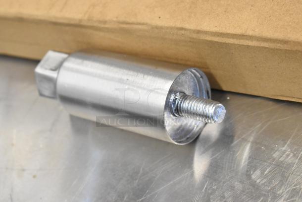 Stainless steel part with threaded end on a flat surface next to a cardboard box.