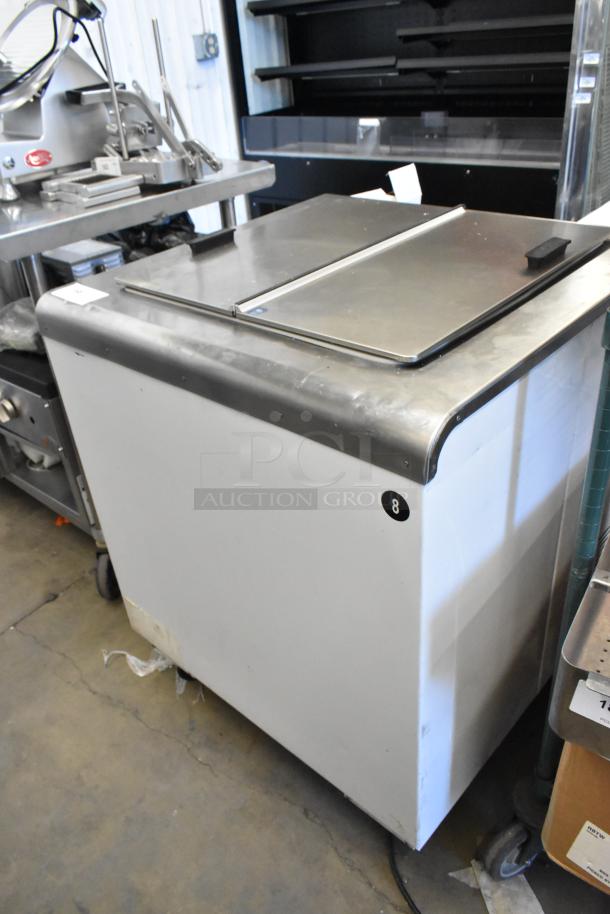 Global Metal commercial chest freezer on casters, metal finish, sliding lid, used condition, labeled "8" on the side.