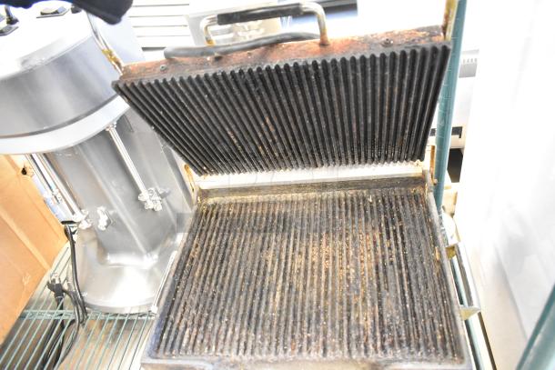 Waring WPG250B stainless steel panini press, 208 volts, well-used, showing grill plates and handle.