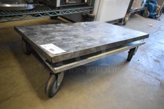 Metal dolly on commercial casters, sturdy design, visible wear. Label marked "785" indicates auction number.