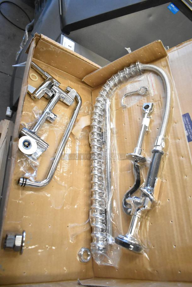 Brand new T&S faucet with spray nozzle, scratch and dent condition, chrome finish, includes fittings and hose in packaging.