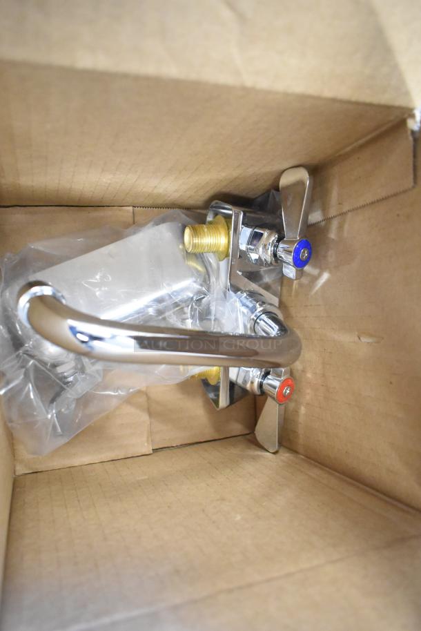 Brand new metal faucet in box, chrome finish, visible scratch and dent, marked hot and cold handles.