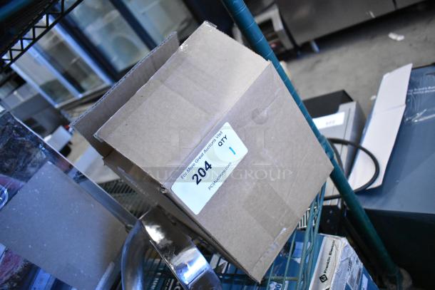 Cardboard box labeled "204 QTY 1," containing brand new scratch and dent metal faucet. Packaging is intact.