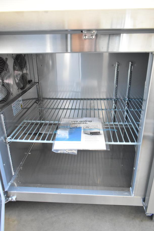 Brand new Avantco 178SSPPT3 stainless steel pizza prep table, 115V, 1 phase, on commercial casters, with shelving and labels.