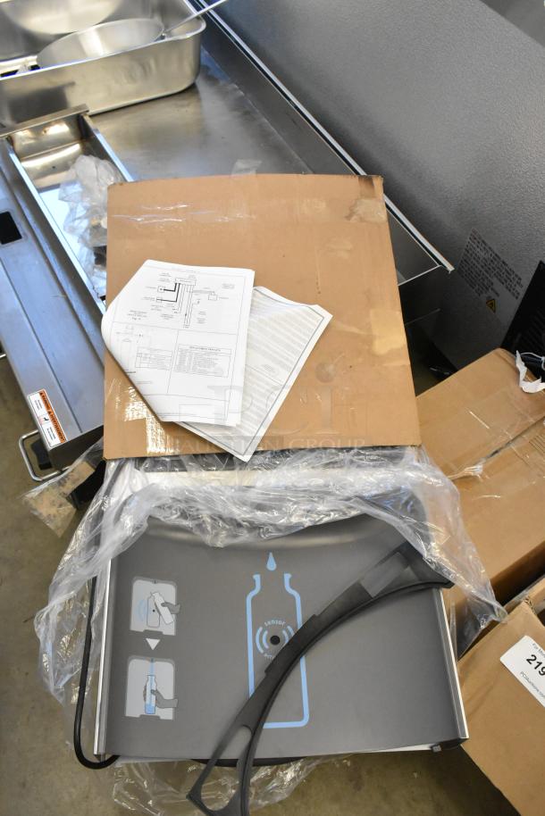 Three brand new scratch-and-dent items, including a water bottle filling attachment, with instructions visible.