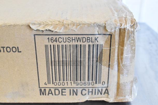 Damaged cardboard box showing barcode and part number 164CUSHWDBLK, labeled "Made in China," for Lancaster seating.