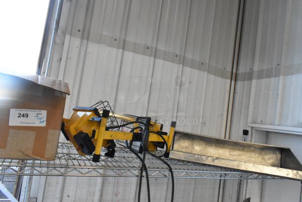 Alt text: Tier lot including yellow work light and box labeled "249 QTY Tier Lot" on a metal shelf.