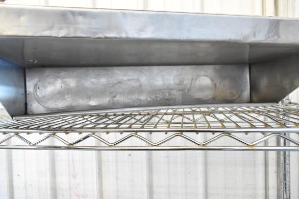 Tier lot with assorted items including a work light and Speedwell. Items in used condition on a metal shelf.