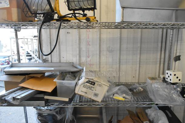 Various items, including dice, serving tongs, and a MyZone MZ-3 band, on a metal shelf. Mixed condition.