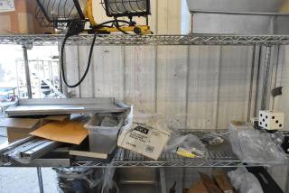 Various items, including dice, serving tongs, and a MyZone MZ-3 band, on a metal shelf. Mixed condition.