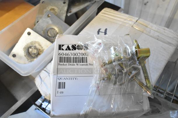 Various auction items including metal pieces, dice, commercial casters, serving tongs, and a MyZone MZ-3 band.