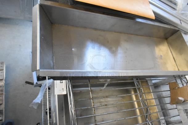 Alt text: Metal tray on a rack with auction tag, showing light wear and signs of use. Part of mixed items lot.