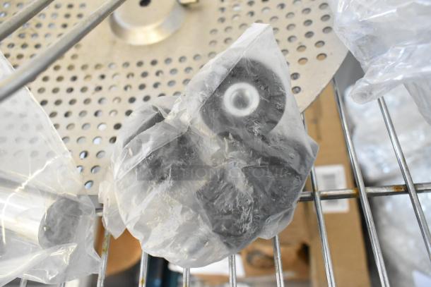 Auction lot of various items including sealed commercial casters, metal pieces, and MyZone MZ-3 band in new condition.