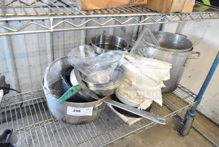 Lot of kitchen items on shelf includes metal stock pots, brew baskets, and white bowls. Label: "258, 1 lot."