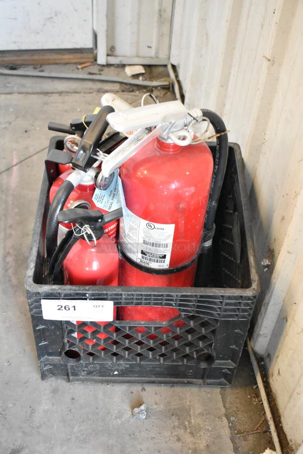 Set of 5 red fire extinguishers in black crate, various sizes, with visible UL certification labels. Buyer pickup required.