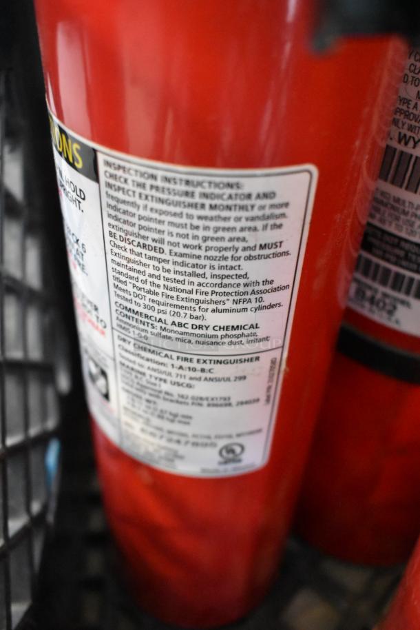 Close-up of a red ABC dry chemical fire extinguisher. Instructions and safety labels visible. Part of a lot of 5. Pickup only.