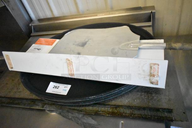 8 items including metal pizza peel and serving trays. Items show wear. Lot number 262 visible on label.