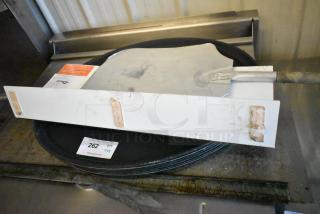 8 items including metal pizza peel and serving trays. Items show wear. Lot number 262 visible on label.