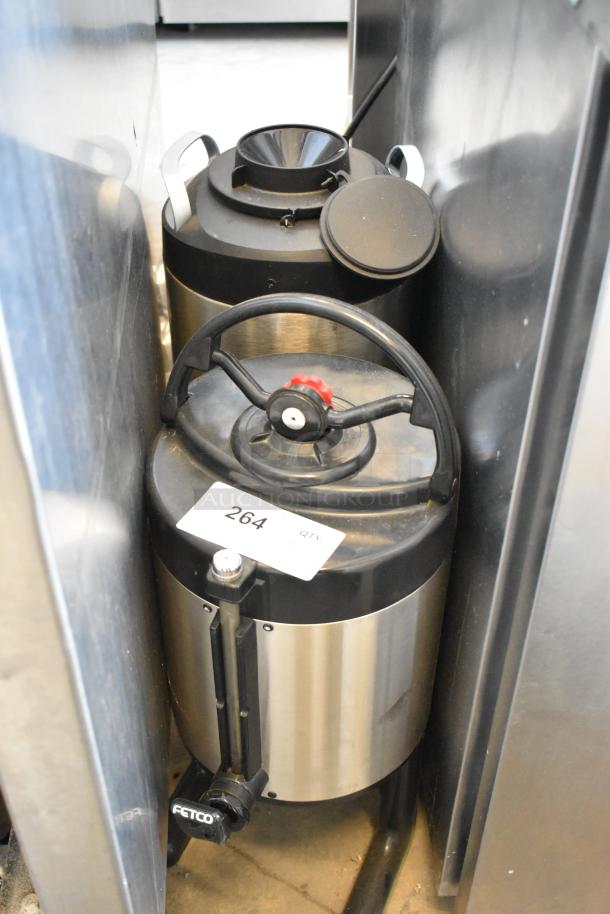 2 Fetco/Curtis stainless steel beverage dispensers with lids and handles, visible spout, and label with number 264.