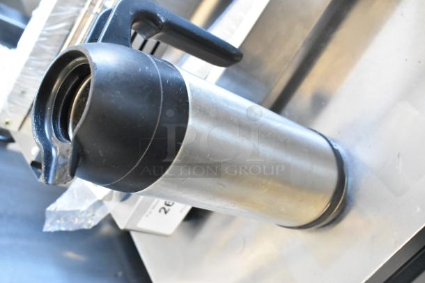 Curtis stainless steel beverage holder with black lid, used condition, reflective metallic body, part of a 4-item set auction.