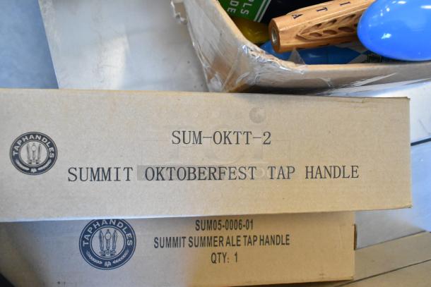 Nine brand new tap handles in boxes, including models SUM-OKTT-2 and SUM05-0006-01. Summit branding visible.