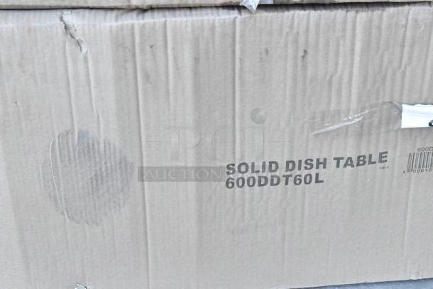 Cardboard box with text "SOLID DISH TABLE 600DDT60L." Visible scratch and dent marks on packaging.