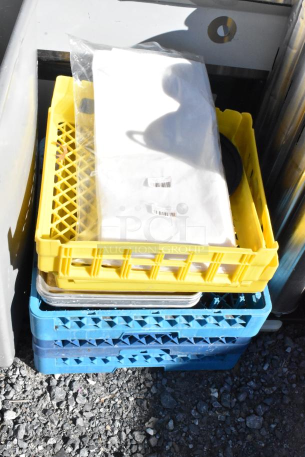Lot with yellow and blue poly glass racks, white sheet with barcodes, on gravel. Includes gray Slim Jim trash can. Good condition.