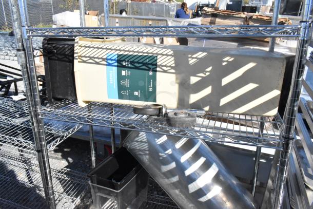 Chrome finish 4-tier wire shelving unit with contents on commercial casters, includes recycle bin and spare wheels.