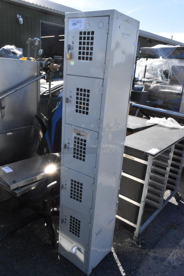 Tan metal locker with 5 cubbies, vented doors, used condition. Includes padlock; label with number 286 visible.