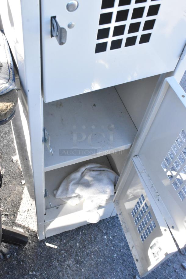 Tan metal 5 cubby locker with vented doors, showing minor wear and open compartments. Ideal for storage needs.