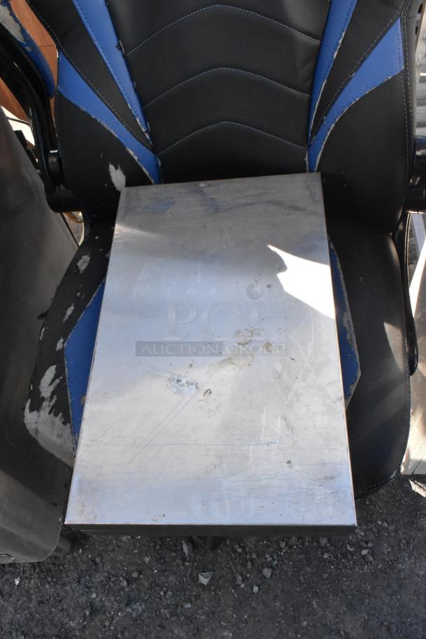 Two metal panels with a shiny surface, visible scratches and marks, resting on a chair. Suitable for fabrication projects.