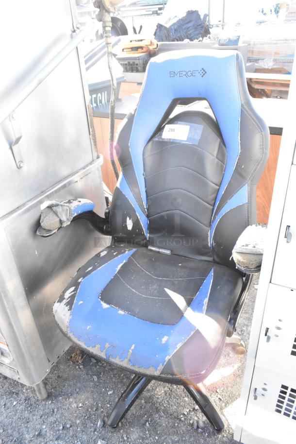 Emerge blue and black gaming chair on casters, showing significant wear and tear, with peeling upholstery and visible padding.