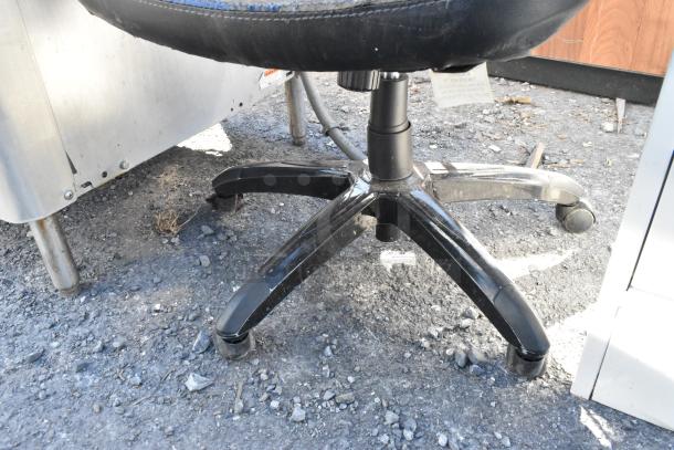 Blue and black gaming chair on casters, Emerge brand, base and partial seat visible, showing signs of use.