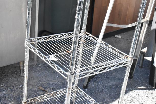 Chrome finish 5-tier wire shelving unit in used condition, buyer must dismantle. Ideal for storage, consider freight charges.