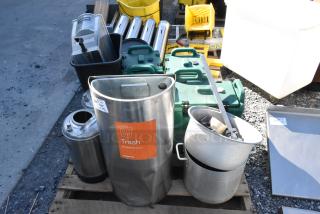 Pallet of assorted items including a metal trash can labeled "Trash," beverage dispensers, and wet floor signs.