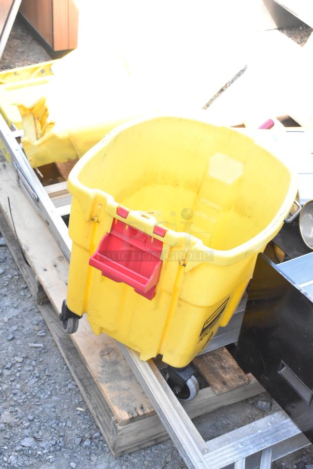 Pallet lot with items including a yellow mop bucket on wheels, metal trash can, and wet floor caution signs, in used condition.