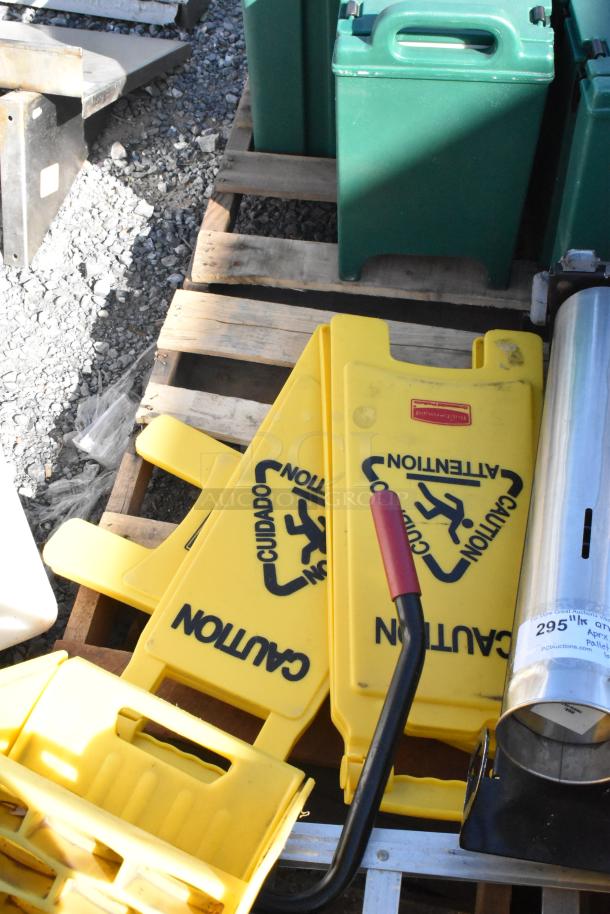 Pallet of items: yellow caution signs, green dispensers, metal trash can, various accessories. Mixed condition.