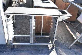 Metal commercial pan transport rack with multiple slots on sturdy commercial casters; used condition.
