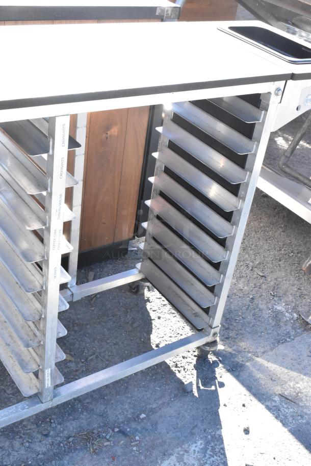 Metal commercial pan transport rack with multiple shelves and commercial casters. Markings for croissants, coffee cakes. Good condition.