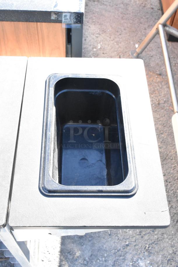 Metal commercial pan transport rack with multiple shelves, visible casters for mobility, sturdy condition.