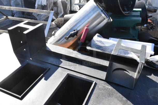 Steel frame with trash deposit holes and tool trays, part of wood pattern trash can shell, shows outdoor usage marks.
