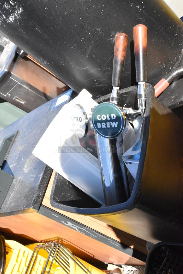 Pallet of various items, including a yellow poly mop bucket and trash cans. Cold brew and nitro taps also visible.