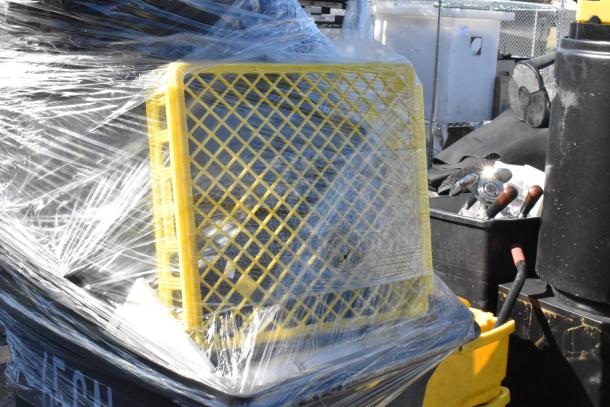 Poly trash can wrapped in plastic with contents including a yellow crate and various tools inside. Good condition.