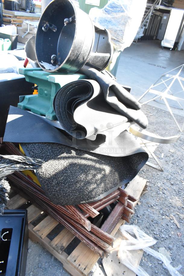 Pallet lot of various items including rolled floor mats, black stool, and several serving tray stands. Items appear used.
