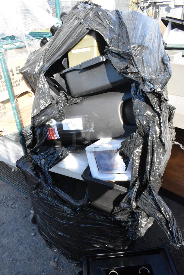Pallet containing various items including a trash can and bus bin, partially wrapped in black plastic. Condition appears used.