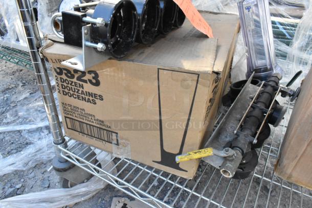 Chrome finish 3-tier wire shelving unit with contents: trash bin, Libbey tall beer glasses, Dixie Ultra dispenser. Buyer to dismantle.