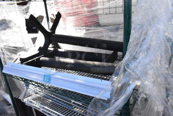 Green 4-tier wire shelving unit with contents including metal shelves. Buyer must dismantle. Wrapped in protective plastic.