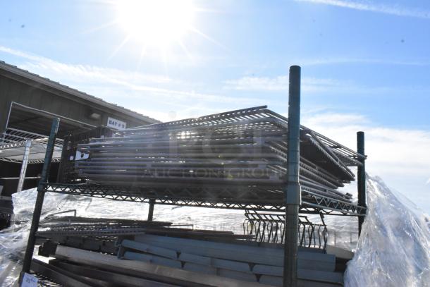 Green finish 4-tier wire shelving unit with metal shelves and contents. Requires dismantling by buyer.