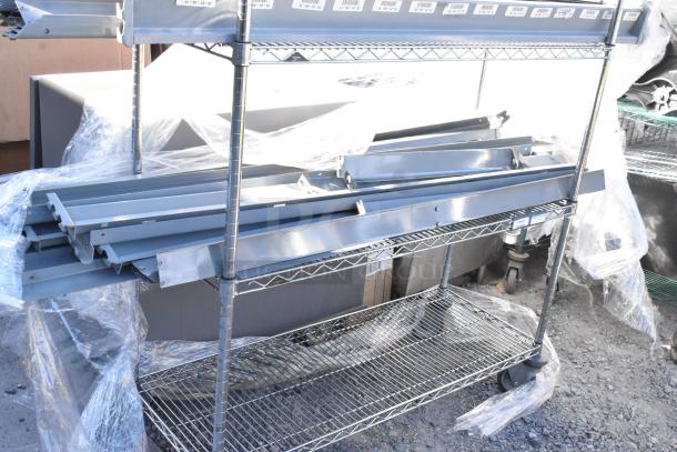 Chrome finish 4-tier wire shelving unit on commercial casters, includes metal pieces. Buyer must dismantle.