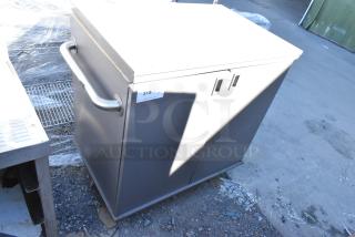 Gray 2 door cart on commercial casters, features a metal handle and label "315" indicating auction item number.